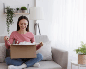 Woman in living area sat on the sofa opening a direct mail box