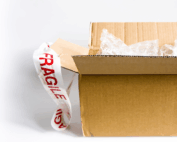 open brown box with gift wrapping and fragile tape