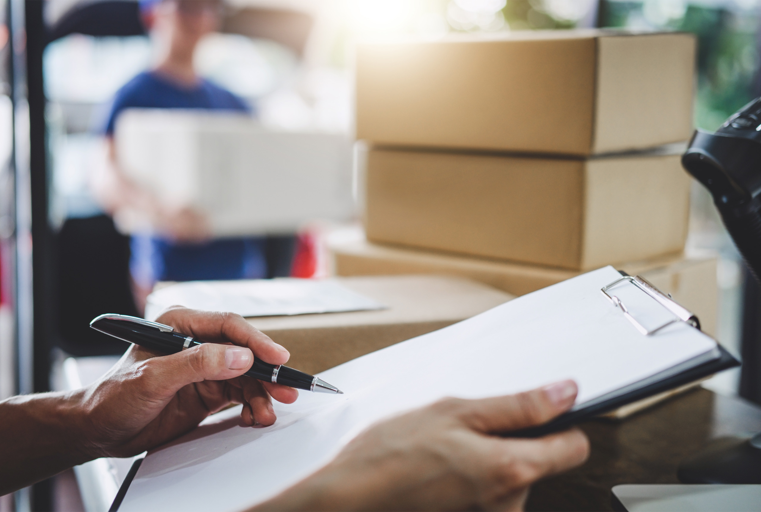 signing for post with boxes and paper