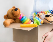 Toys overflowing from cardboard box.